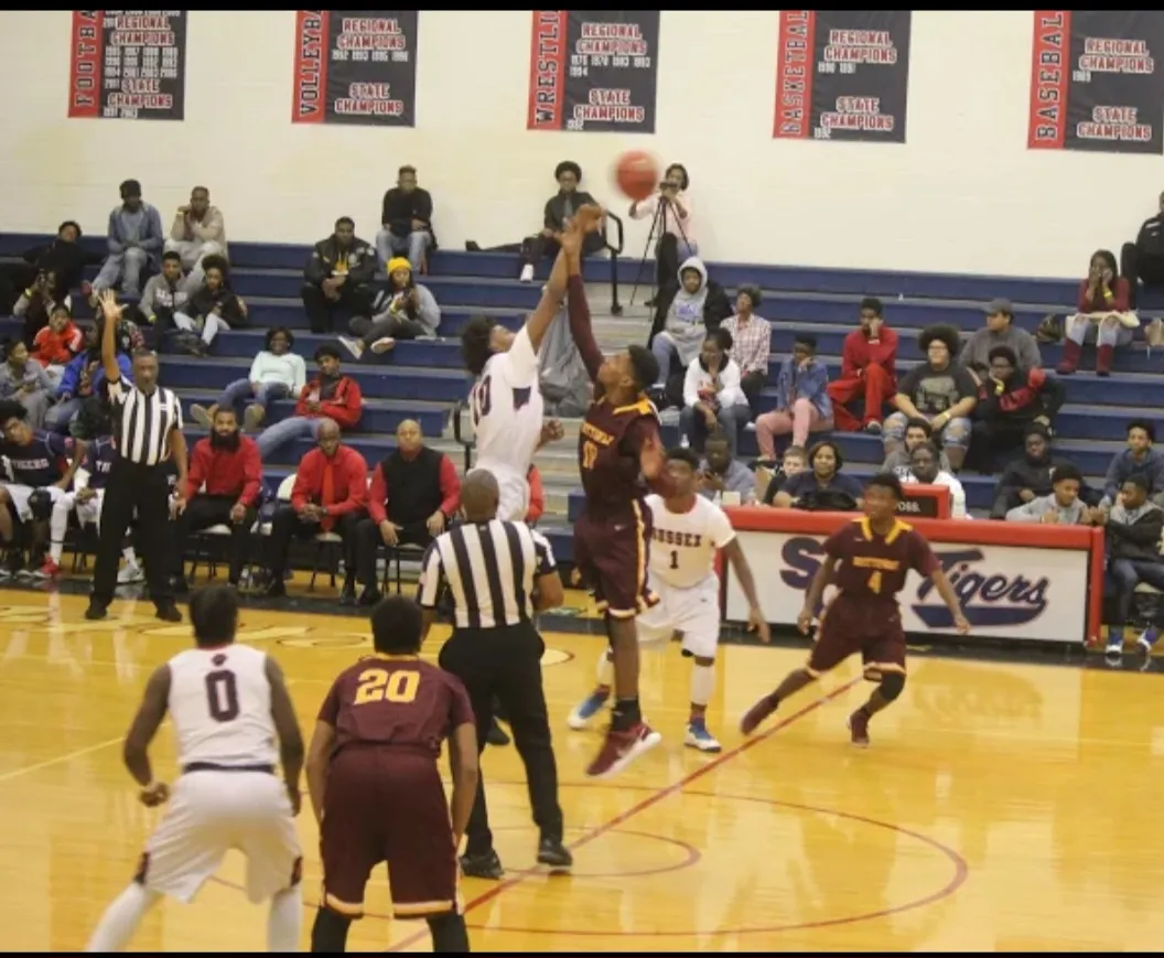 Sussex Central Tigers basketball game under championship banners